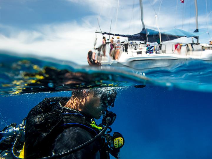Scuba diver diving below a boat