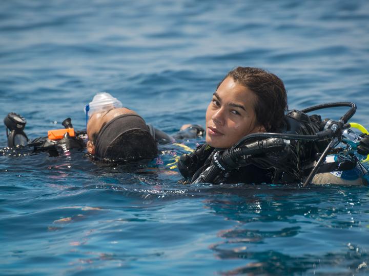 Diver with a pile of diving equipment.